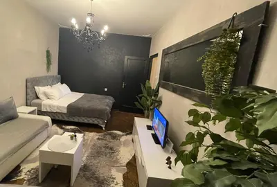 a living room with a couch and a tv on a table at Okapi stays in Belgrade