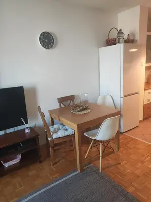 a kitchen with a wooden table with chairs and a refrigerator at Urban nest Slavija in Belgrade