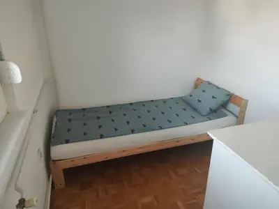a small bench with a blue pillow in a room at Urban nest Slavija in Belgrade
