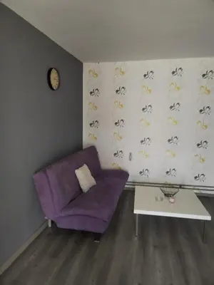 a living room with a purple couch and a table at Apartman M&D in Pančevo