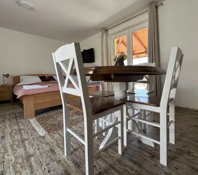 a table and chairs in a room with a bedroom at Forest House in Beljina