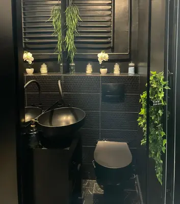 a bathroom with two sinks and a toilet and plants at Knez in Belgrade