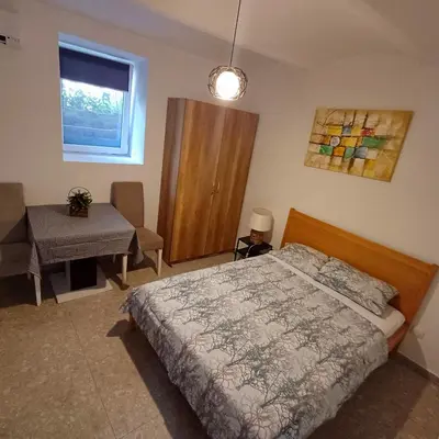 a bedroom with a bed and a table and a window at Lela in Belgrade