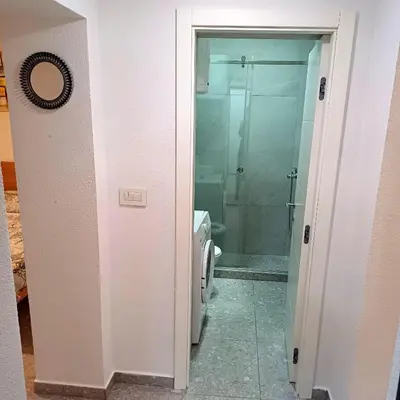 a bathroom with a glass shower and a toilet at Lela in Belgrade