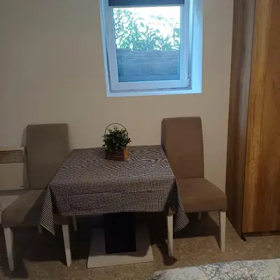a table and two chairs with a table and a window at Lela in Belgrade