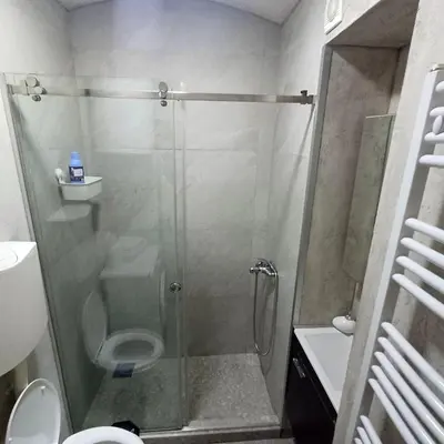 a bathroom with a glass shower with a toilet at Lela in Belgrade