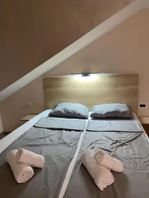 a large bed with two pillows and towels on it at Apartman Masa in Arandjelovac