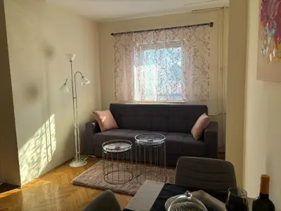 a living room with a couch and a window at Urban Yard Retreat in Belgrade