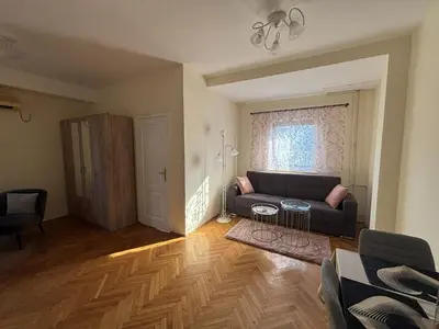 a living room with a couch and a window at Urban Yard Retreat in Belgrade