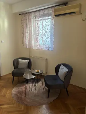 a living room with two chairs and a table and a window at Urban Yard Retreat in Belgrade