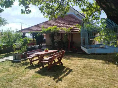 a picnic table in front of a small house at Bukuljska kuća in Arandjelovac