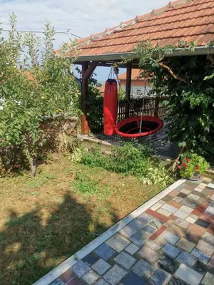 a garden with a gazebo with a red swing at Bukuljska kuća in Arandjelovac
