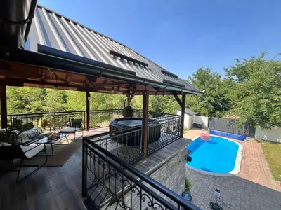 an outdoor deck with a swimming pool and a pavilion at Vila Peščana Tišina in Banatski Karlovac