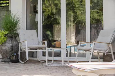 three chairs and a table on a porch at Vila Peščana Tišina in Banatski Karlovac