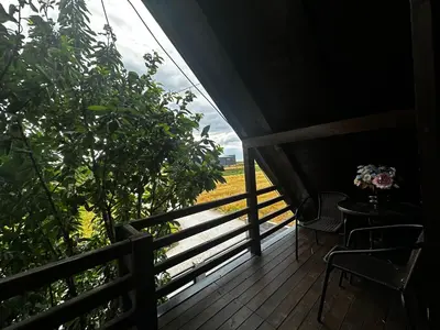 a porch with a table and chairs and a field at Taca House - Airport apartman in Surčin
