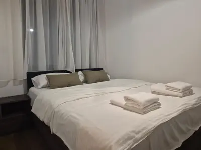 a white bed with towels on top of it at Lastavica residence, modern luxury apartment with garage in Novi Beograd
