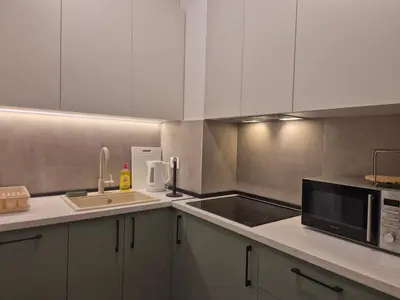 a kitchen with white cabinets and a sink and a microwave at Lastavica residence, modern luxury apartment with garage in Novi Beograd