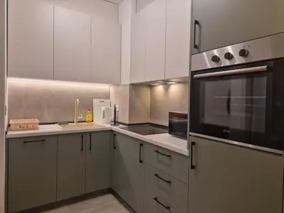 a kitchen with white cabinets and a black appliance at Lastavica residence, modern luxury apartment with garage in Novi Beograd