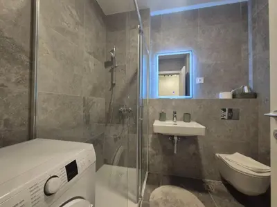 a bathroom with a toilet and a sink and a shower at Lastavica residence, modern luxury apartment with garage in Novi Beograd