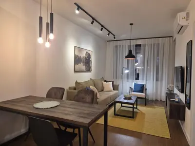a living room with a table and a couch at Lastavica residence, modern luxury apartment with garage in Novi Beograd