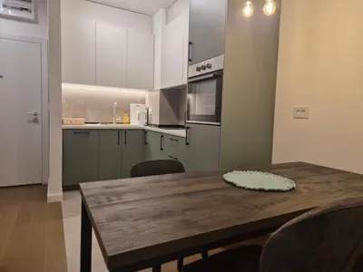a kitchen with a wooden table and a dining room at Lastavica residence, modern luxury apartment with garage in Novi Beograd