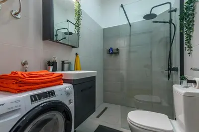 a bathroom with a washing machine and a shower at Studio 44 in Belgrade