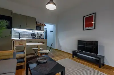 a living room with a kitchen and a living room with a table at Studio 44 in Belgrade