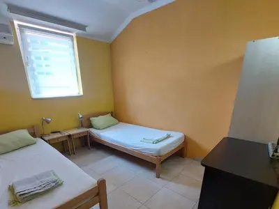 a small room with two beds and a window at Maja Rooms & Garden in Smederevo