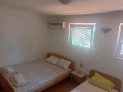a small bedroom with a bed and a window at Maja Rooms & Garden in Smederevo