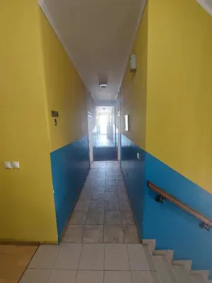 an empty hallway with yellow and blue walls and stairs at Maja Rooms & Garden in Smederevo