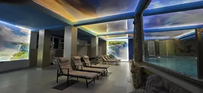 a hotel lobby with a swimming pool and chairs at Bali Colosseum Hotel in Belgrade
