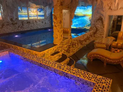 a swimming pool in a house with a blue lighting at Bali Colosseum Hotel in Belgrade