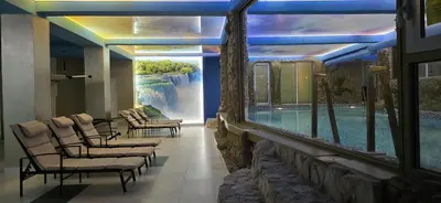 a room with chairs and a swimming pool at Bali Colosseum Hotel in Belgrade