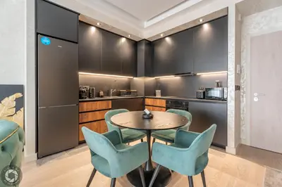 a kitchen with a table and blue chairs at Elegant 2BR BW Apartment 2 Bathrooms -Private Garage A1 Residence Bw in Belgrade