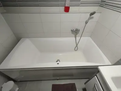a shower in a white tiled bathroom at Miran San Apartment Belgrade in Mali Mokri Lug