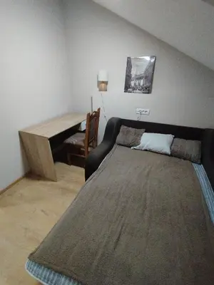 a bedroom with a bed and a table and a piano at Miran San Apartment Belgrade in Mali Mokri Lug