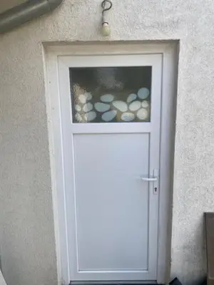 a white door with a window in a wall at Imanje Mihailovic in Pružatovac