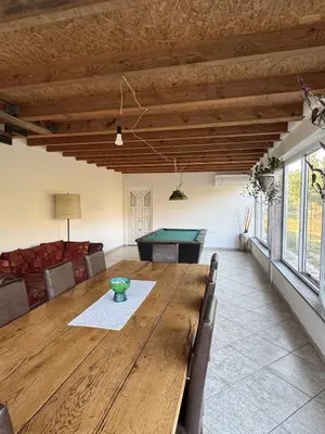 a dining room with a table and a pool table at Imanje Mihailovic in Pružatovac