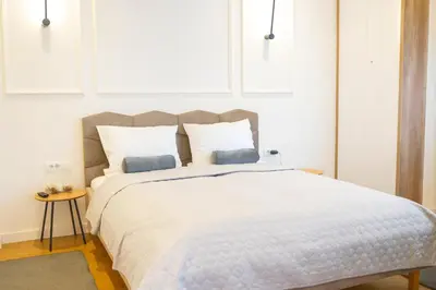a bedroom with a large white bed with two pillows at Central Belgrade Apartments in Belgrade