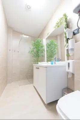 a white bathroom with a shower and a sink at Central Belgrade Apartments in Belgrade