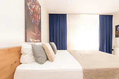 a bedroom with a large white bed with pillows at Central Belgrade Apartments in Belgrade