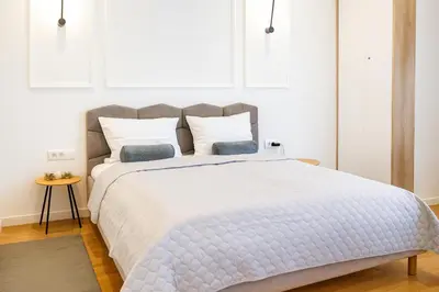 a bedroom with a large white bed with two pillows at Central Belgrade Apartments in Belgrade