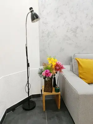a living room with a couch and a lamp and flowers at Urban Garden Apartments - Iris in Belgrade