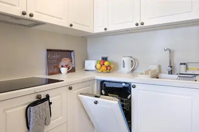 a kitchen with white cabinets and a dishwasher at New Luxury Dorcol Downtown Apartment in Belgrade