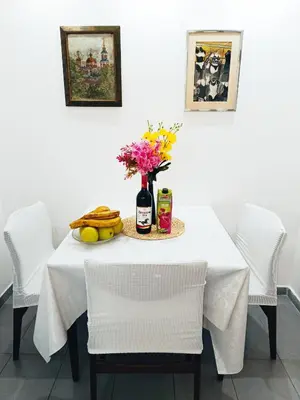 a white table with a vase of flowers and fruit at Urban Garden Apartments - Sunflower in Belgrade