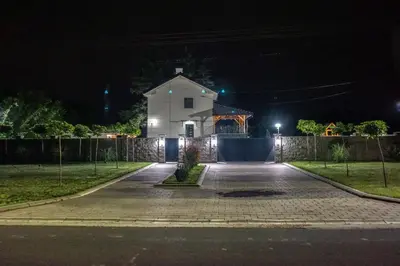 a white building at night with a fence at Vila Gospođica in Progar