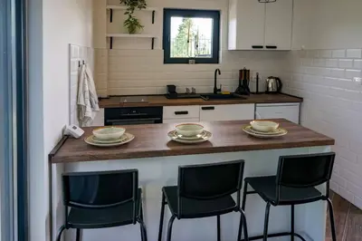 a kitchen with a counter with four chairs at it at Vila Gospođica in Progar