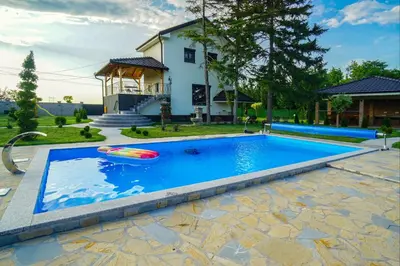 a swimming pool with a inflatable raft in front of a house at Vila Gospođica in Progar