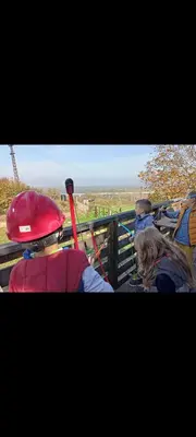 a group of people looking at a giraffe behind a fence at Eko dan in Železnička Stanica Karlovački Vinogradi