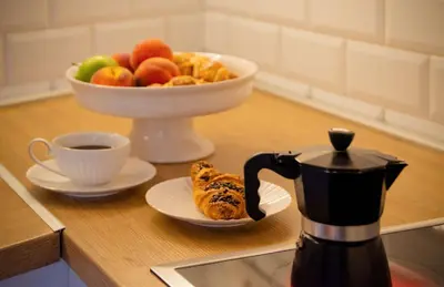 a table with a bowl of fruit and a cup of coffee at Ollio Quiet City Center Apartments in Belgrade